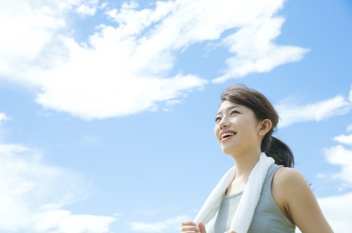 マラソンを終えて達成感を感じる女性イメージ