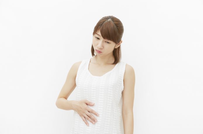 お腹がむくんでいる女性