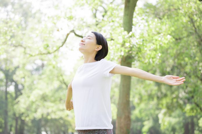 朝の公園で深呼吸をする女性ランナー