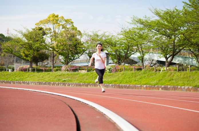 陸上トラックを走る女性