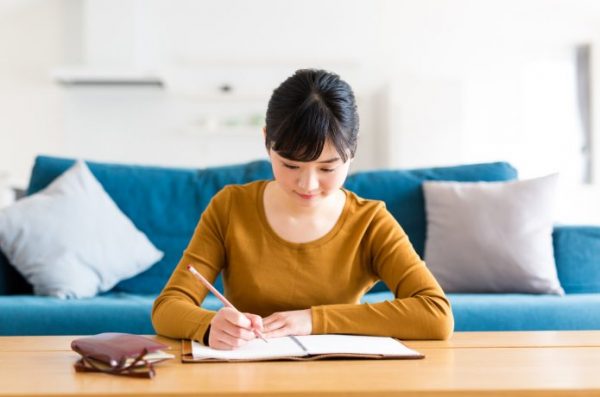 家で書き物をする女性