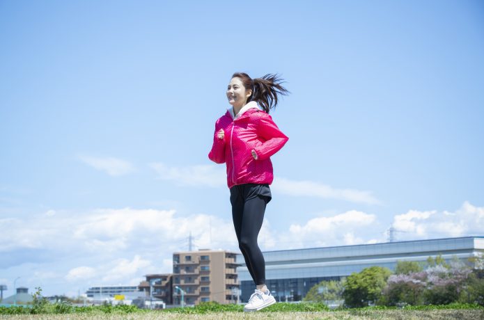 ウインドブレーカーを着て走る女性