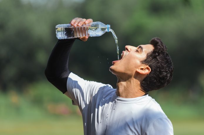 急いで水分補給する男性のイメージ画像