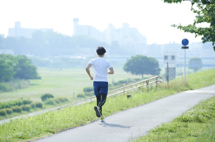 Tシャツとハーフパンツを履いて走る男性