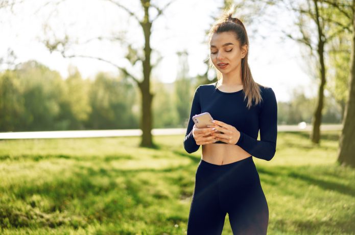 スマホを見るスポーツウェアの女性